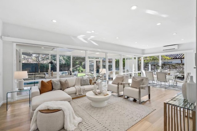 living room with light hardwood / wood-style flooring and a wall mounted AC