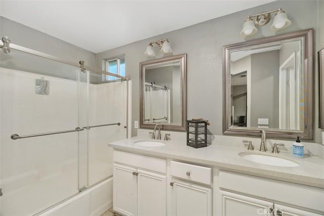 bathroom featuring shower / bath combination with glass door and vanity