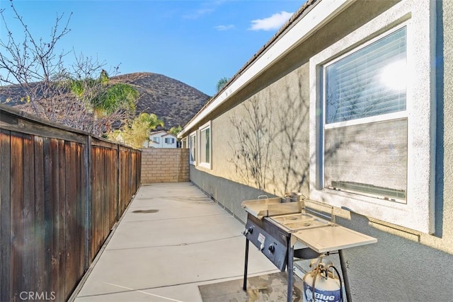 view of side of home featuring a patio area and a mountain view