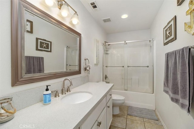 full bathroom with vanity, bath / shower combo with glass door, tile patterned floors, and toilet