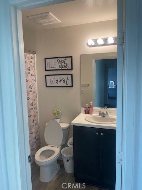 bathroom with vanity, hardwood / wood-style floors, toilet, and walk in shower