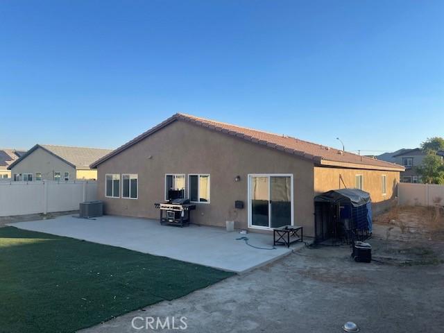 rear view of property featuring cooling unit and a patio area