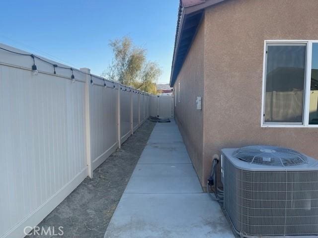 view of property exterior featuring cooling unit and a patio