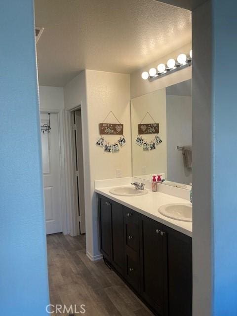 bathroom featuring vanity, wood-type flooring, and a textured ceiling