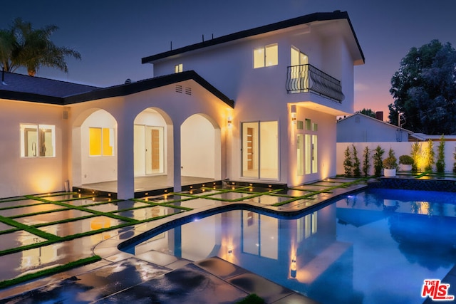 rear view of house featuring a patio area and a fenced in pool