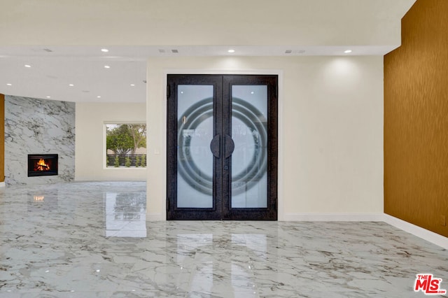 entrance foyer with french doors and a high end fireplace