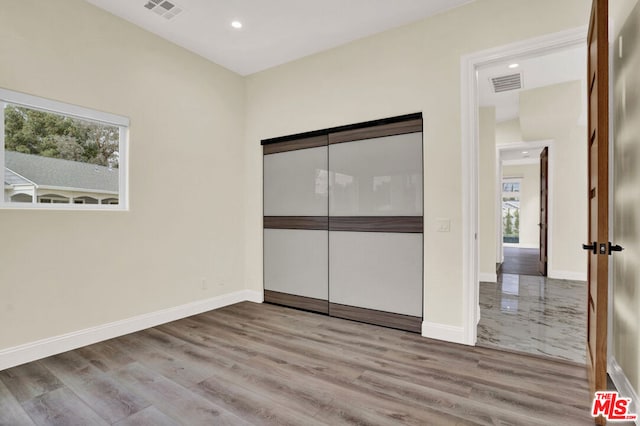 unfurnished bedroom featuring a closet and light hardwood / wood-style flooring