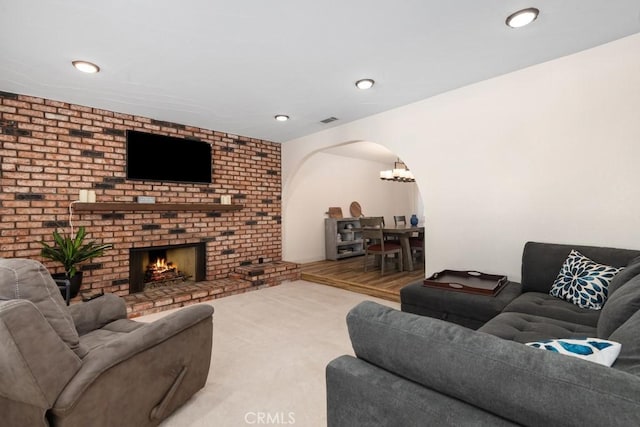 living room with a brick fireplace and carpet floors