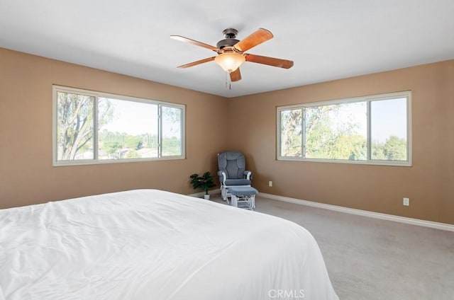 carpeted bedroom featuring ceiling fan and multiple windows