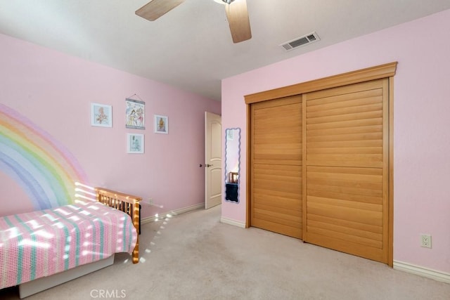 carpeted bedroom featuring ceiling fan and a closet