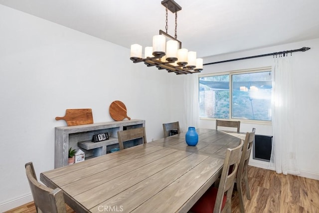 dining area featuring light hardwood / wood-style floors and an inviting chandelier