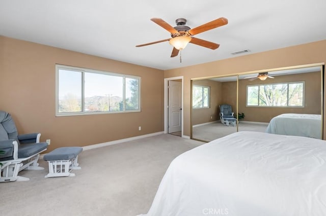 bedroom with a closet, ceiling fan, and light colored carpet