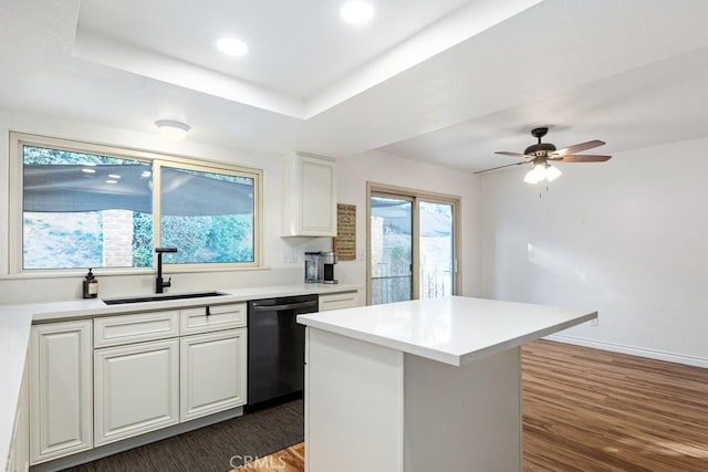 kitchen featuring sink, white cabinets, a raised ceiling, and black dishwasher