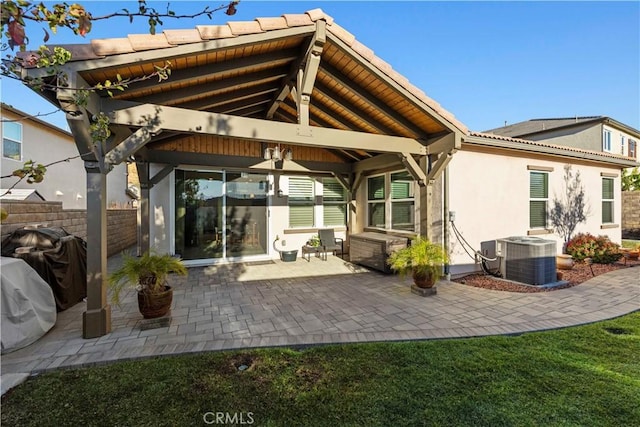 back of house featuring a patio area, a gazebo, central AC unit, and a yard