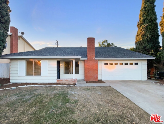 single story home featuring a front lawn and a garage