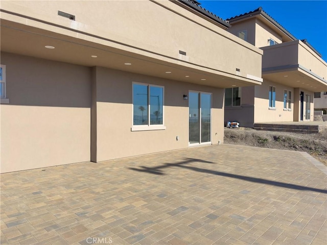 back of property with a patio area and stucco siding