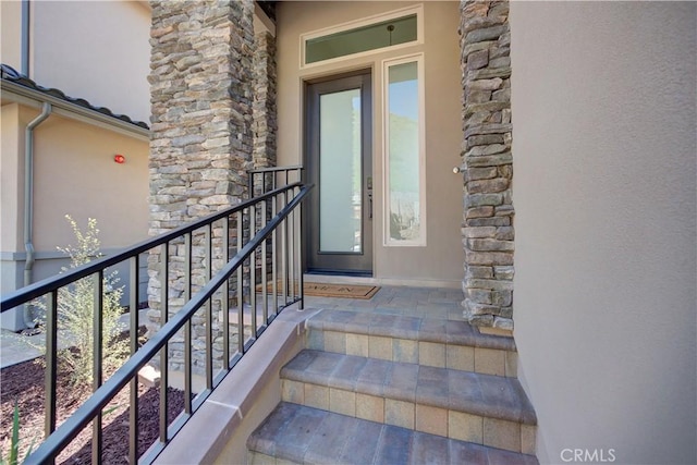 property entrance with stone siding and stucco siding