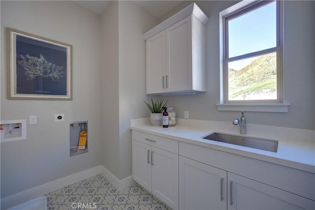 laundry area with hookup for a washing machine, cabinet space, a sink, electric dryer hookup, and baseboards