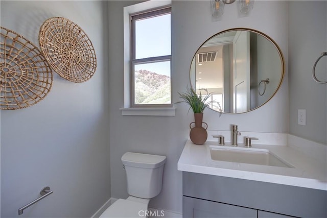 bathroom with visible vents, vanity, and toilet