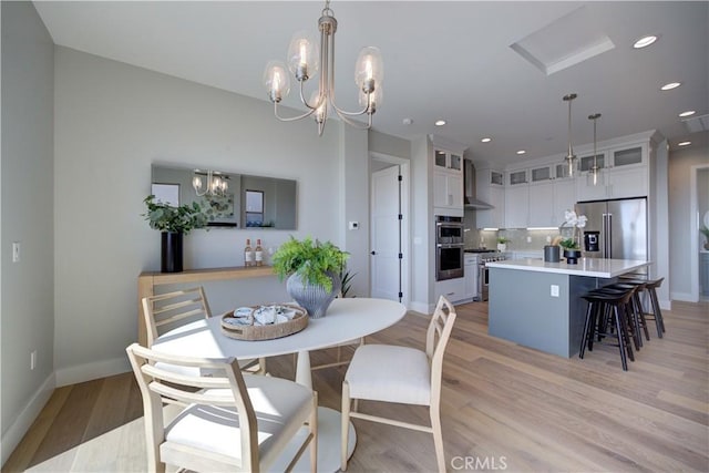 dining space with light wood-style floors, recessed lighting, baseboards, and an inviting chandelier