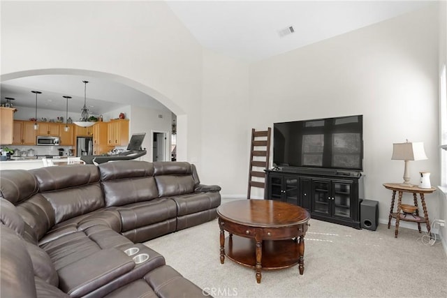 carpeted living room with high vaulted ceiling