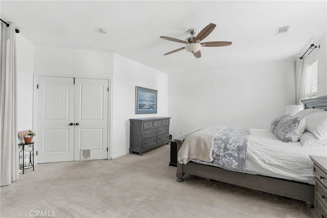 carpeted bedroom with ceiling fan and a closet