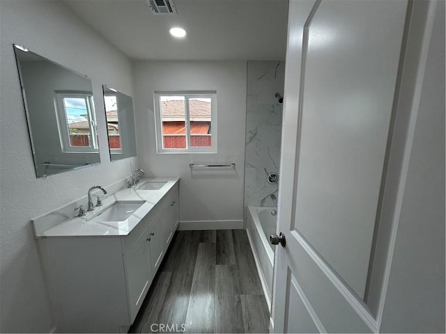 bathroom featuring hardwood / wood-style flooring,  shower combination, and vanity