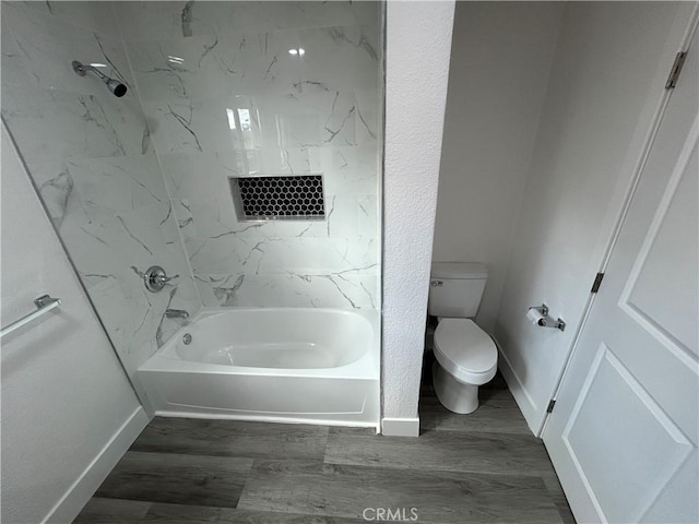 bathroom with bathing tub / shower combination, toilet, and hardwood / wood-style flooring