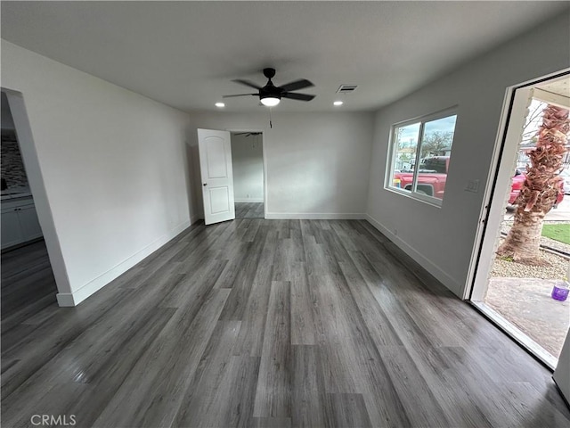 unfurnished room featuring ceiling fan and dark wood-type flooring