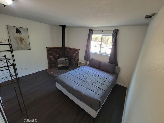 45412 N Oakview Dr, Oakhurst, CA 93644 - bedroom featuring dark wood-style flooring and a wood stove