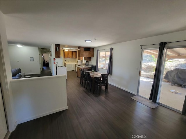 dining room featuring independent washer and dryer, dark wood finished floors, and baseboards