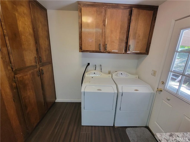 clothes washing area featuring dark wood-style floors, cabinet space, independent washer and dryer, and baseboards