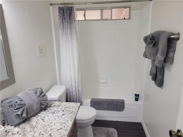 full bath featuring toilet, shower / tub combo, vanity, wood finished floors, and baseboards