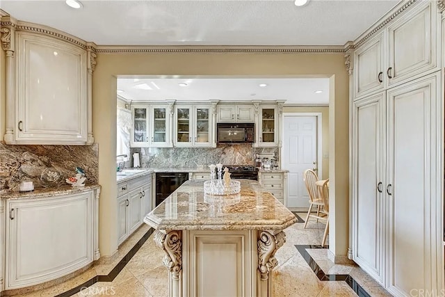 kitchen with a kitchen island, tasteful backsplash, a kitchen bar, black appliances, and light stone countertops