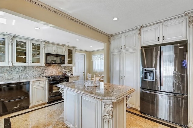 kitchen with decorative backsplash, glass insert cabinets, light stone counters, black appliances, and recessed lighting