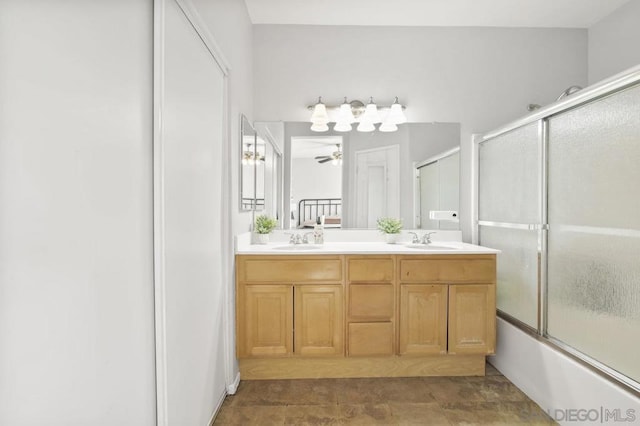 bathroom with combined bath / shower with glass door, ceiling fan, and vanity