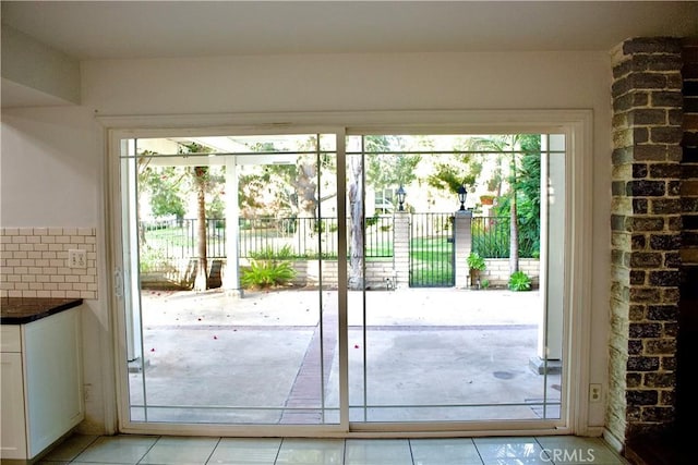 doorway to outside with light tile patterned flooring