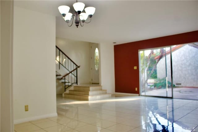 tiled foyer featuring a wealth of natural light and a chandelier