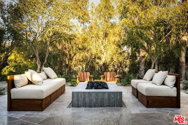 view of patio with an outdoor living space with a fire pit