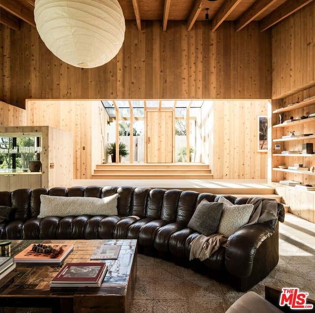 living room with beamed ceiling, a high ceiling, and a wealth of natural light