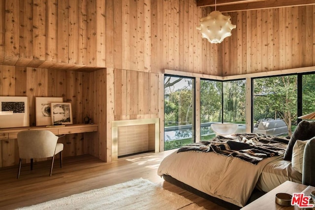 bedroom featuring light hardwood / wood-style floors and a high ceiling