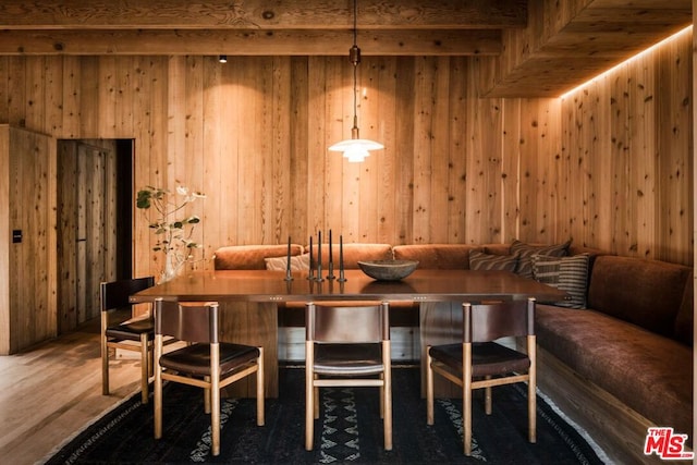 dining room with breakfast area, wooden walls, and hardwood / wood-style floors