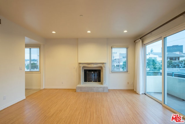 unfurnished living room with a premium fireplace and light hardwood / wood-style flooring