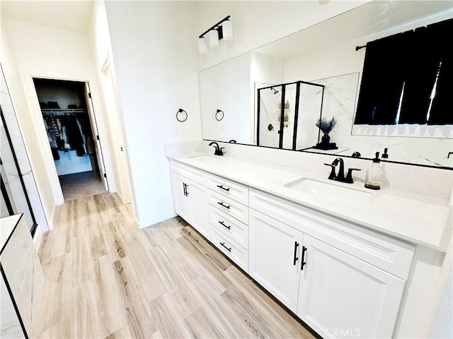 bathroom with hardwood / wood-style floors, an enclosed shower, and vanity