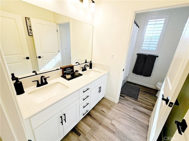 bathroom featuring toilet, vanity, and hardwood / wood-style flooring