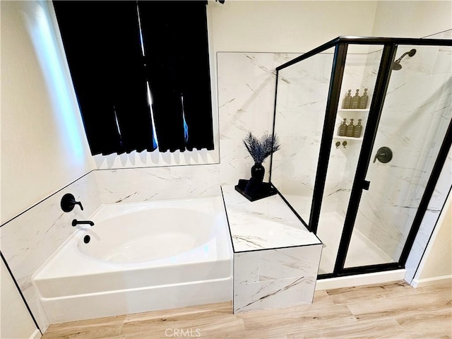 bathroom with shower with separate bathtub and wood-type flooring