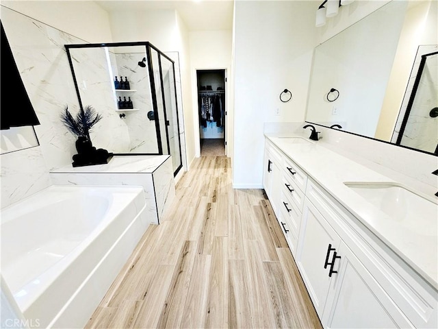 bathroom with wood-type flooring, vanity, and separate shower and tub