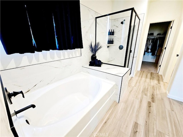 bathroom featuring independent shower and bath and hardwood / wood-style floors