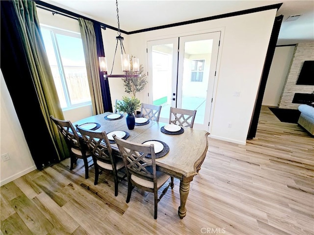 dining space with light hardwood / wood-style flooring and a chandelier