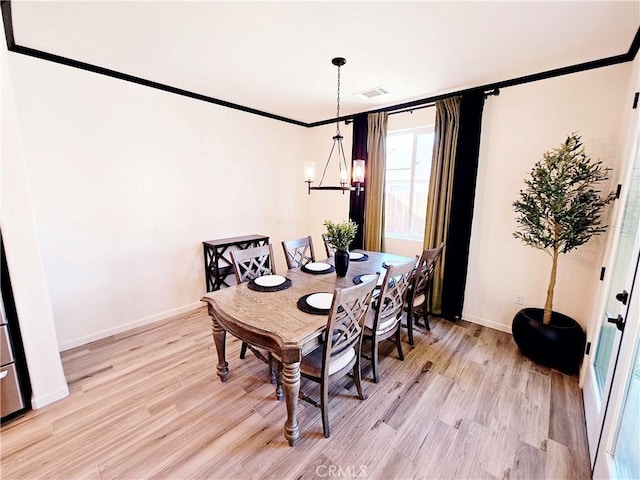 dining room with a notable chandelier and light wood-type flooring